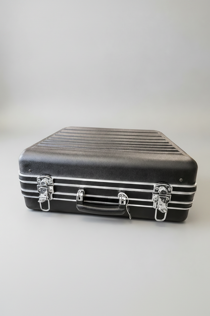Black suitcase with silver straps on a white background